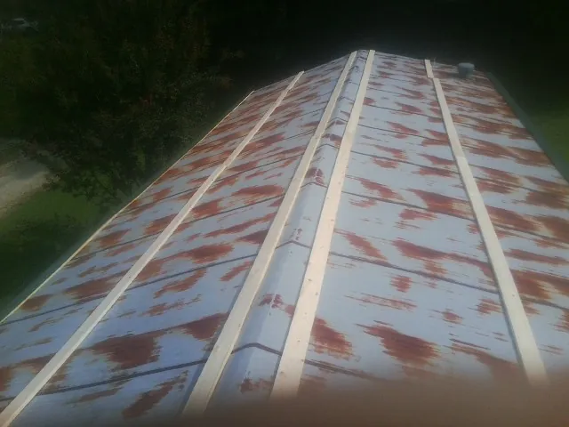 Rusted metal roof panels with new wood purlins before replacement — Storm Damage Roof Repair in Rumsey by Roofing Brothers